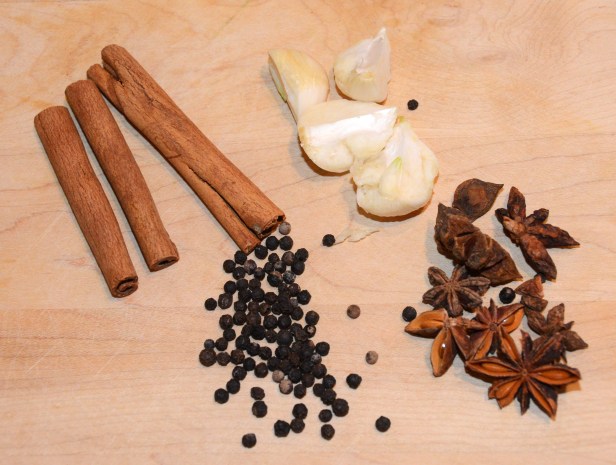Clockwise from top: cinnamon sticks, fresh garlic, star anise, black peppercorn